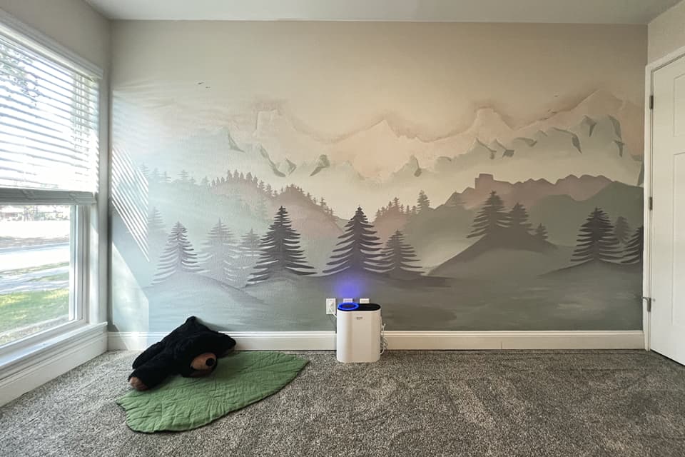 Hand-painted mountain landscape mural with layered peaks and evergreen trees